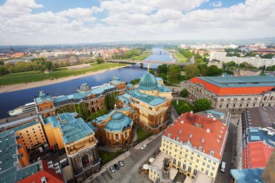 High angle view of buildings by river against sky