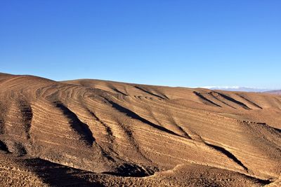 Scenic view of desert against clear blue sky