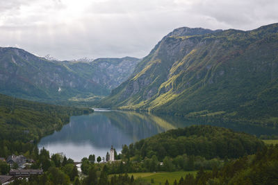 Scenic view of lake and mountains against cloudy sky