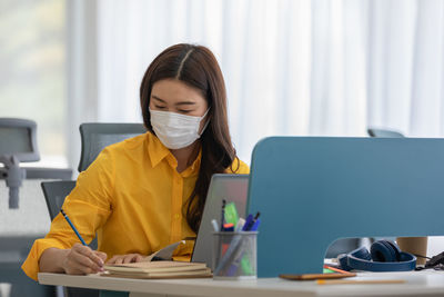 Businesswoman wearing mask working in office