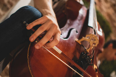 Midsection of man holding cello