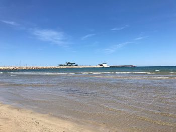 Scenic view of beach against blue sky