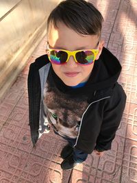 Portrait of boy wearing sunglasses standing on footpath