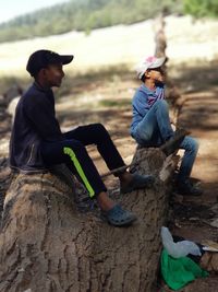 Rear view of friends sitting on land