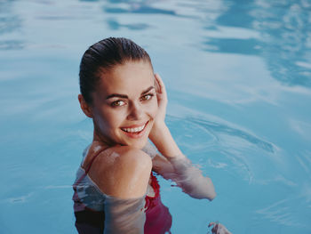 Portrait of smiling young woman in swimming pool