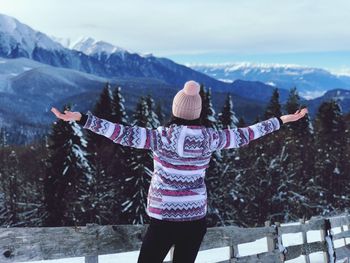 Full length of woman standing on snow covered mountain