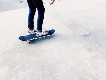 Low section of child standing on skateboard