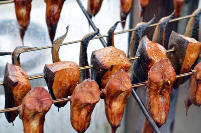 Close-up of dry leaves hanging on metal fence