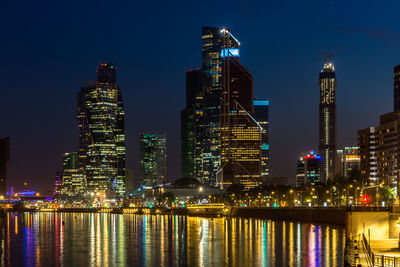 Illuminated buildings against sky at night