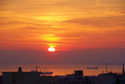 Silhouette buildings against romantic sky at sunset