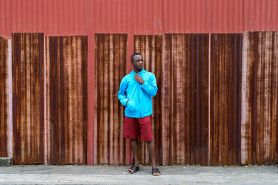 Portrait of man standing against wall