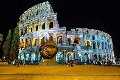 Low angle view of people on illuminated building at night