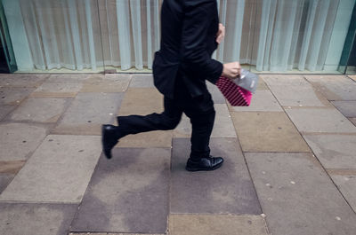 Low section of man walking on footpath