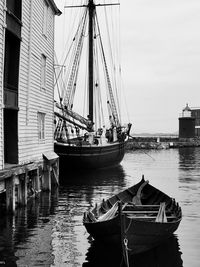 Sailboats moored in sea against sky