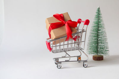 Close-up of miniature shopping cart against white background