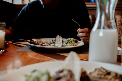 Midsection of woman having food in restaurant