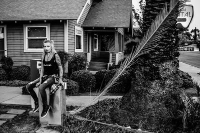 Woman standing by house