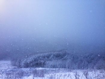 Scenic view of snowcapped field against sky