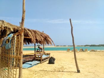 Lounge chairs on beach against sky