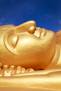 Close-up of buddha statue against sky