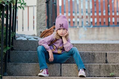 Portrait of a young girl sat on a step with attitude waiting