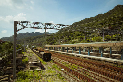 Railroad tracks by bridge against sky