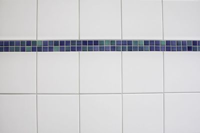 Close-up of white tiled wall