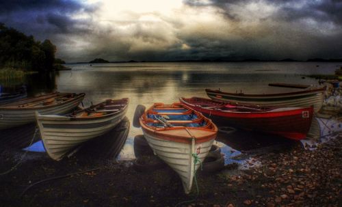 Boats in sea against cloudy sky