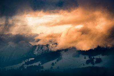 Scenic view of snowcapped mountains against sky during sunset