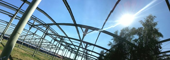 Low angle view of sun shining through clouds