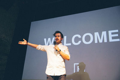 Man giving presentation while standing in front of projection screen