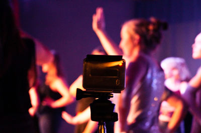 Close-up of woman photographing illuminated camera