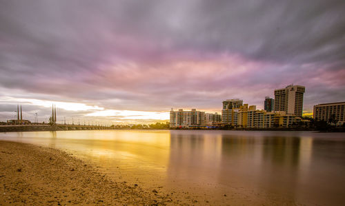 River by illuminated city against sky at night