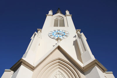 Low angle view of bell tower against blue sky