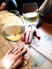 Midsection of woman holding drink on table