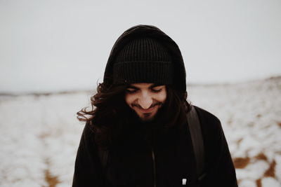 Portrait of young woman standing in sea against sky