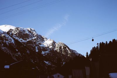 Low angle view of snowcapped mountains against clear sky