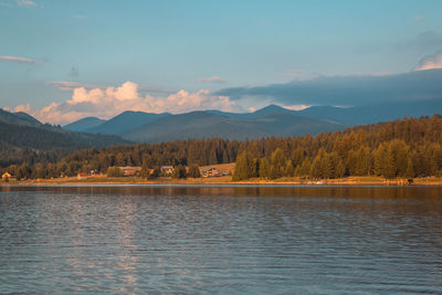 Scenic view of lake by mountains against sky