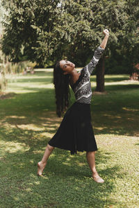 Full length of young woman dancing on land