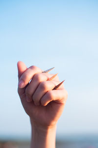 Midsection of person holding hands against clear sky