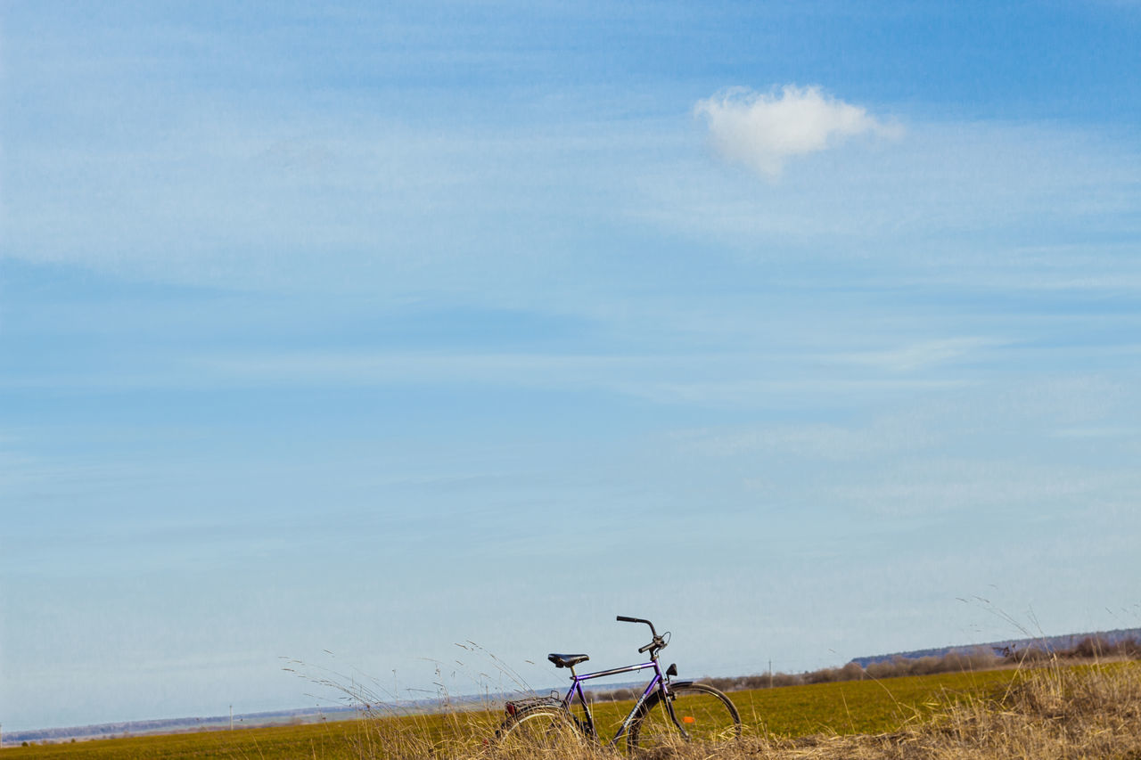 sky, horizon, bicycle, cloud, nature, prairie, transportation, day, field, land, rural area, landscape, wind, grassland, scenics - nature, no people, tranquility, beauty in nature, tranquil scene, environment, vehicle, grass, hill, plain, plant, agriculture, land vehicle, non-urban scene, outdoors, mode of transportation, sea, blue
