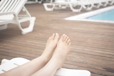 Low section of woman relaxing at poolside