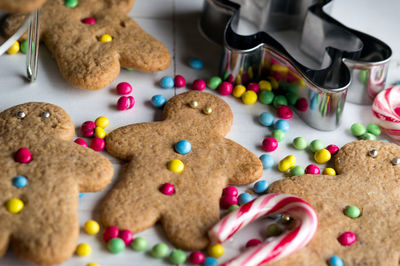 Close-up of gingerbread cookies with cutter and candy cane on table