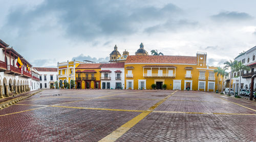 Buildings in city against cloudy sky