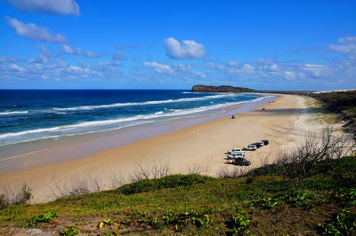 Scenic view of beach against blue sky