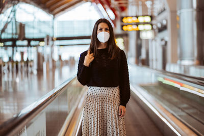 Portrait of young woman standing in city