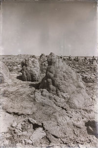 Rock formations on beach against sky