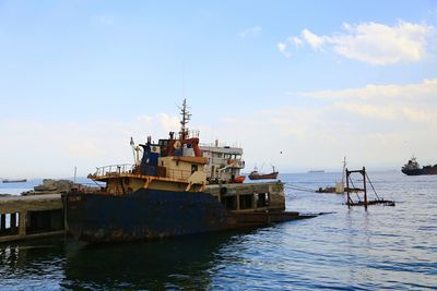 Ship moored on sea against sky