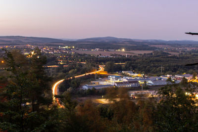 High angle view of illuminated city against sky at dusk