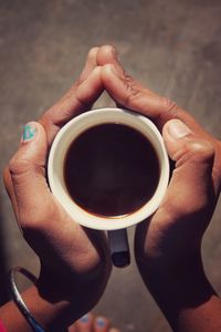 Close-up of hand holding coffee cup